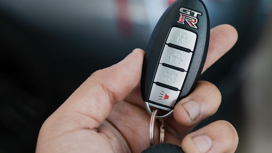 Hand holding a Nissan key fob
