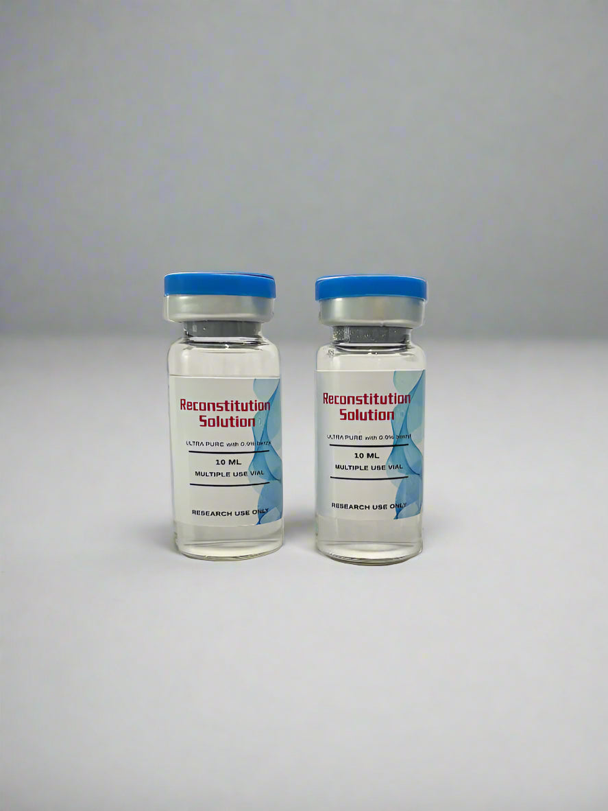 Three vials with blue caps and labels in front of a black box with gold text on a white background